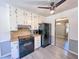 Eat-in kitchen with white cabinets, black appliances, wood countertops, modern gray flooring and ceiling fan at 3814 Lamar Way, Snellville, GA 30039