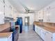 Galley kitchen with white cabinets, wood countertop, black appliances and modern gray flooring at 3814 Lamar Way, Snellville, GA 30039