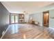 Open concept living room features a ceiling fan, wood floors, stone fireplace, and a sliding glass door at 3814 Lamar Way, Snellville, GA 30039
