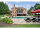 Spacious backyard featuring a pool, lounge chairs, covered porch and well-maintained landscaping at 5475 Copper Creek Pass, Cumming, GA 30040