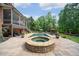 Backyard patio with spa, pool, lush lawn, screened porch on a brick two-story home surrounded by mature trees at 5475 Copper Creek Pass, Cumming, GA 30040