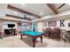 Basement with a pool table, brick accents, beamed ceilings and dark wood bar stools at 5475 Copper Creek Pass, Cumming, GA 30040