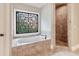 Luxurious bathroom with a soaking tub, decorative window, and separate shower at 5475 Copper Creek Pass, Cumming, GA 30040