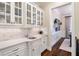 Elegant butler's pantry with white cabinetry, marble backsplash, and convenient access to the dining area at 5475 Copper Creek Pass, Cumming, GA 30040