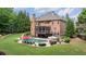 An aerial view of the home showcasing the brick exterior, screened porch, backyard pool, and lush greenery at 5475 Copper Creek Pass, Cumming, GA 30040