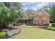 Charming two-story brick home with stone accents, covered front porch, and manicured landscaping at 5475 Copper Creek Pass, Cumming, GA 30040