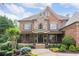 Charming brick and stone home showcasing meticulous landscaping and inviting front porch at 5475 Copper Creek Pass, Cumming, GA 30040