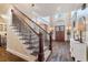 Grand staircase leading to the second floor, complemented by dark hardwood floors and sophisticated foyer decor at 5475 Copper Creek Pass, Cumming, GA 30040