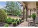 Covered front porch with stone flooring and view of the lush front yard landscaping at 5475 Copper Creek Pass, Cumming, GA 30040