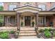 Inviting front porch with stone columns, double doors, and elegant landscaping at 5475 Copper Creek Pass, Cumming, GA 30040