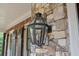 Close up of exterior light fixture on stone and brick home, showing natural light and architectural interest at 5475 Copper Creek Pass, Cumming, GA 30040