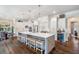 Spacious kitchen with large center island, seating, stainless steel appliances, custom cabinetry, and wood flooring at 5475 Copper Creek Pass, Cumming, GA 30040