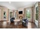 Cozy living room featuring a stone fireplace, flatscreen TV, and hardwood floors at 5475 Copper Creek Pass, Cumming, GA 30040