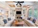 Bright living room with coffered ceilings, stone fireplace, built-in shelves, and large windows overlooking the backyard at 5475 Copper Creek Pass, Cumming, GA 30040