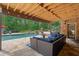 Inviting covered patio featuring a stone floor, comfortable seating, and a view of the refreshing pool at 5475 Copper Creek Pass, Cumming, GA 30040
