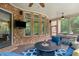 Covered brick patio with ceiling fans, outdoor seating, and a tv at 5475 Copper Creek Pass, Cumming, GA 30040
