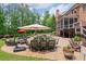 An outdoor patio with outdoor table and chairs, lush green lawn, and mature trees surround the house at 5475 Copper Creek Pass, Cumming, GA 30040