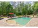 Inviting backyard featuring a pool, spa, tanning ledge, and elegant stone patio at 5475 Copper Creek Pass, Cumming, GA 30040