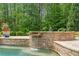 Relaxing backyard pool area featuring a waterfall feature and lush landscaping at 5475 Copper Creek Pass, Cumming, GA 30040