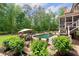 Backyard with a pool, spa, outdoor dining area, lounge chairs, and lush landscaping at 5475 Copper Creek Pass, Cumming, GA 30040