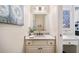 Stylish powder room with a white vanity, quartz countertop, and decorative mirror at 5475 Copper Creek Pass, Cumming, GA 30040