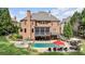 Large brick home with an in-ground pool, outdoor seating, and screened-in porch at 5475 Copper Creek Pass, Cumming, GA 30040