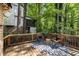 Outdoor deck with wooded view, seating, and a black and white rug at 203 Concorde Sw Way, Lilburn, GA 30047