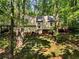 Spacious backyard featuring mature trees and a deck, offering a private outdoor space at 203 Concorde Sw Way, Lilburn, GA 30047