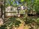 Secluded backyard with mature trees, featuring a deck, creating a peaceful retreat at 203 Concorde Sw Way, Lilburn, GA 30047