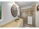 Bathroom showcasing a vanity with a single sink, a glass-enclosed shower with tan tile, and a window at 203 Concorde Sw Way, Lilburn, GA 30047