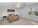 Cozy bedroom with a ceiling fan, patterned bedding, two end tables, and a window showcasing a wooded view at 203 Concorde Sw Way, Lilburn, GA 30047