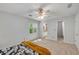 Bedroom featuring a ceiling fan, carpeted floor, and a view into the ensuite bathroom at 203 Concorde Sw Way, Lilburn, GA 30047