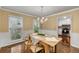 Charming dining room with wood floors and views to the kitchen and the treed outdoor spaces at 203 Concorde Sw Way, Lilburn, GA 30047