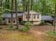 Attractive exterior featuring two-tone siding, stone accents, covered parking and mature shade trees at 203 Concorde Sw Way, Lilburn, GA 30047