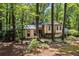 Attractive home exterior featuring siding, stone accents, covered parking and beautiful mature shade trees at 203 Concorde Sw Way, Lilburn, GA 30047