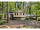Charming home featuring a stone accent base, siding and covered parking, nestled among mature trees at 203 Concorde Sw Way, Lilburn, GA 30047