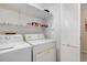Laundry room featuring a washer, dryer, shelving and white folding doors at 203 Concorde Sw Way, Lilburn, GA 30047