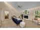 Bright living room featuring a fireplace with white mantle, and a large sunny window overlooking the yard at 203 Concorde Sw Way, Lilburn, GA 30047