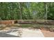 This private backyard features mature trees, wood retaining walls and a concrete patio at 250 Huntcliff Ct, Fayetteville, GA 30214