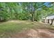 Expansive backyard featuring a large grassy area, mature trees, and the rear exterior of the home at 250 Huntcliff Ct, Fayetteville, GA 30214