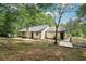 Backyard of home showcasing patio, siding, chimney, mature trees, and spacious surroundings at 250 Huntcliff Ct, Fayetteville, GA 30214