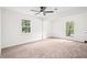 Spacious bedroom with carpet, two windows, and a modern ceiling fan at 250 Huntcliff Ct, Fayetteville, GA 30214