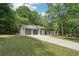 View of the house with a two-car garage and a well-maintained lawn surrounded by lush trees at 250 Huntcliff Ct, Fayetteville, GA 30214