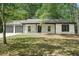 Front of the house with stone accents, a two-car garage, and a lush green lawn at 250 Huntcliff Ct, Fayetteville, GA 30214
