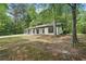 Quaint home featuring stone accents, dark shutters, a well-manicured lawn and mature trees at 250 Huntcliff Ct, Fayetteville, GA 30214