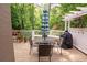 Outdoor deck with table, chairs, and grill surrounded by lush trees and green landscape at 3115 Peachtree Ne Dr, Atlanta, GA 30305