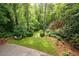Backyard has outdoor lounge space, lush lawn, beautiful plantings, and mature trees at 3115 Peachtree Ne Dr, Atlanta, GA 30305