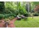 Backyard features outdoor seating, mature trees, bird bath, and a tranquil, green space at 3115 Peachtree Ne Dr, Atlanta, GA 30305