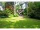 Spacious backyard with a well-manicured lawn and mature trees, leading up to the home at 3115 Peachtree Ne Dr, Atlanta, GA 30305