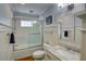 Well-lit bathroom with white tile surround, marble vanity, and glass door tub-shower at 3115 Peachtree Ne Dr, Atlanta, GA 30305